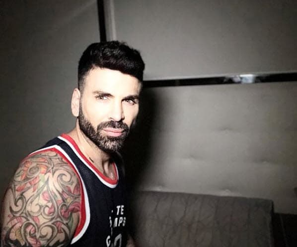 Sus tatuajes en los brazos resaltan cuando viste ropa sin mangas, como este jersey.