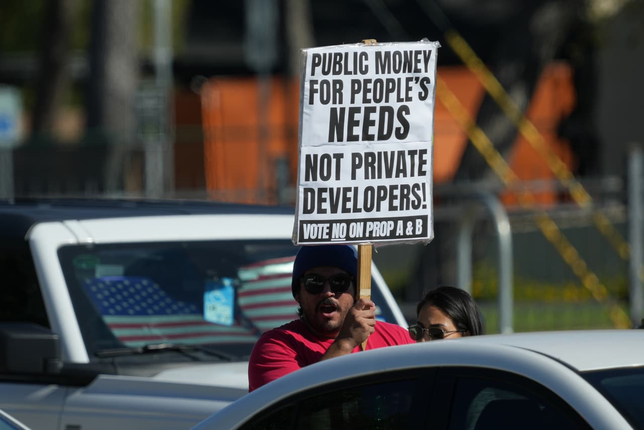 Nico Longoria se manifiesta con un cartel cerca de un colegio electoral en San Antonio para oponerse a las propuestas que se votarán en las elecciones y que destinarían fondos al Rodeo de San Antonio y a un nuevo estadio deportivo para los San Antonio Spurs.
<br>