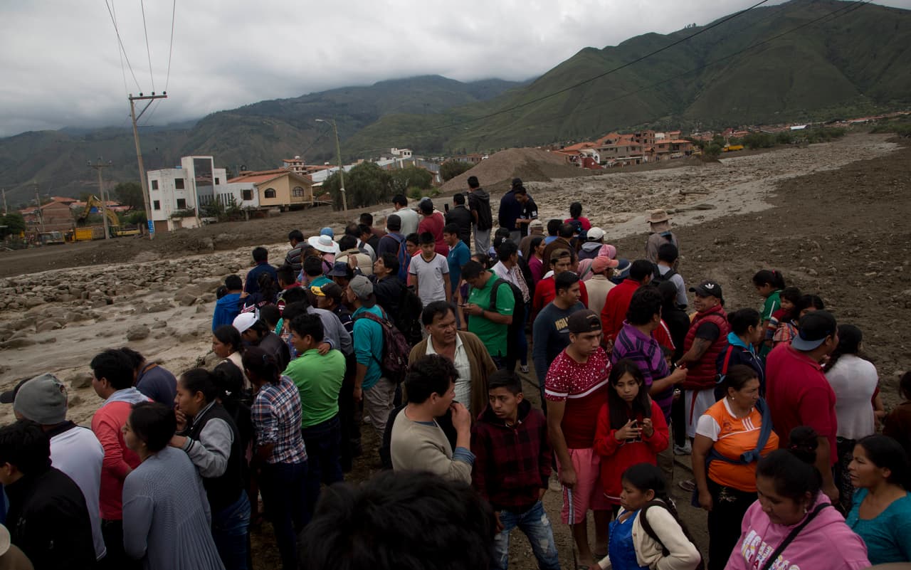 Además, al menos 8,200 familias han tenido que abandonar sus hogares después de que los ríos arrastraran agua y lodo sobre sus viviendas. En la imagen, residentes de Tiquipaya junto al río Taquiña desbordado.