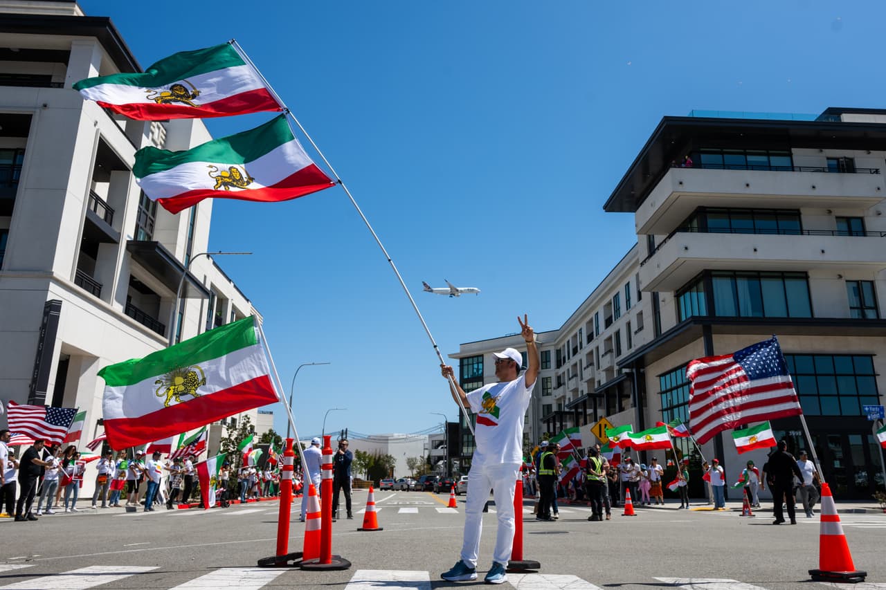 Un hombre sostiene dos banderas iraníes en un gran mástil durante una protesta en reacción a la prohibición de la FIFA de la bandera prerrevolucionaria de Irán en los estadios de la Copa Mundial, el domingo 7 de junio de 2026, en Inglewood, California. (Foto AP/Benjamin Hanson)
<br>
