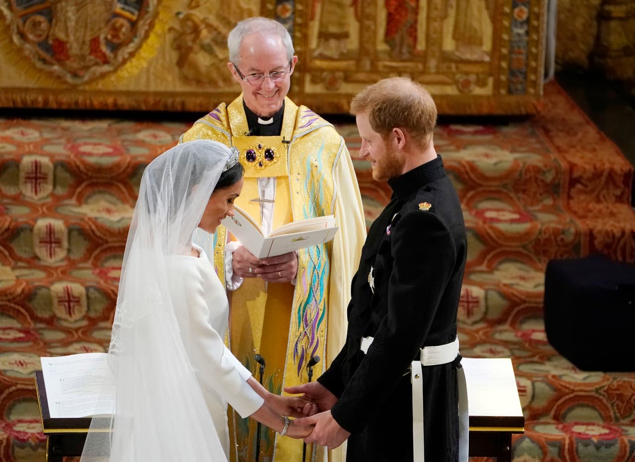 La novia impactó con un 
<b><a href="https://www.univision.com/estilo-de-vida/bodas/el-vestido-de-meghan-markle-el-gran-secreto-ha-sido-revelado">vestido blanco</a></b> de cuello tipo barco de Clare Waight Keller para la casa Givenchy, que incluía un velo que se extendía por varios metros.