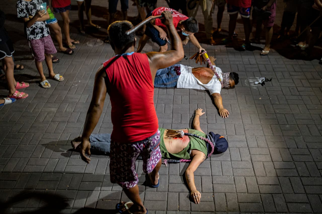 Cristianos representando a Cristo reciben azotes en la espalda frente a una iglesia cerrada en Manila, Filipinas. Desafían las órdenes del gobierno de evitar reuniones religiosas y quedarse en casa para frenar la propagación del covid-19 durante el Viernes Santo.
<br>