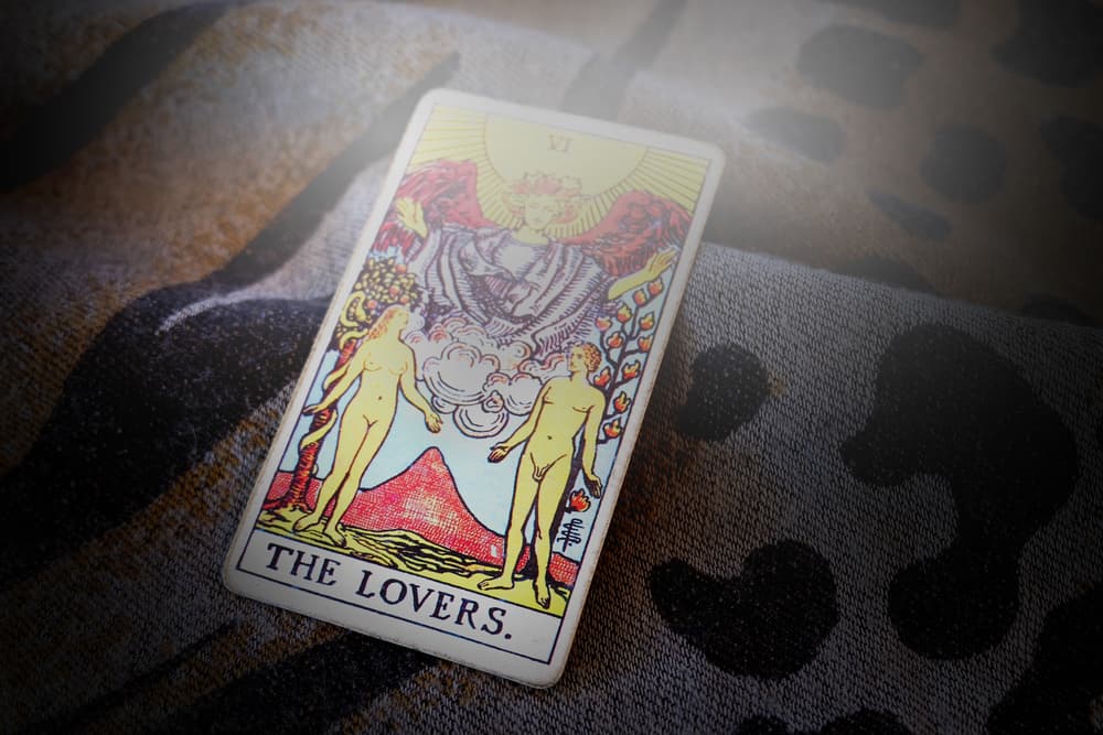 La capa morada del angel simboliza la realeza, un símbolo de cuán importante la comunicación es. El Sol brilla con fuerza sobre los amantes, brindándoles calidez y seguridad. El suelo es verde y fértil, que sugiere no sólo vida, sino prosperidad y felicidad.