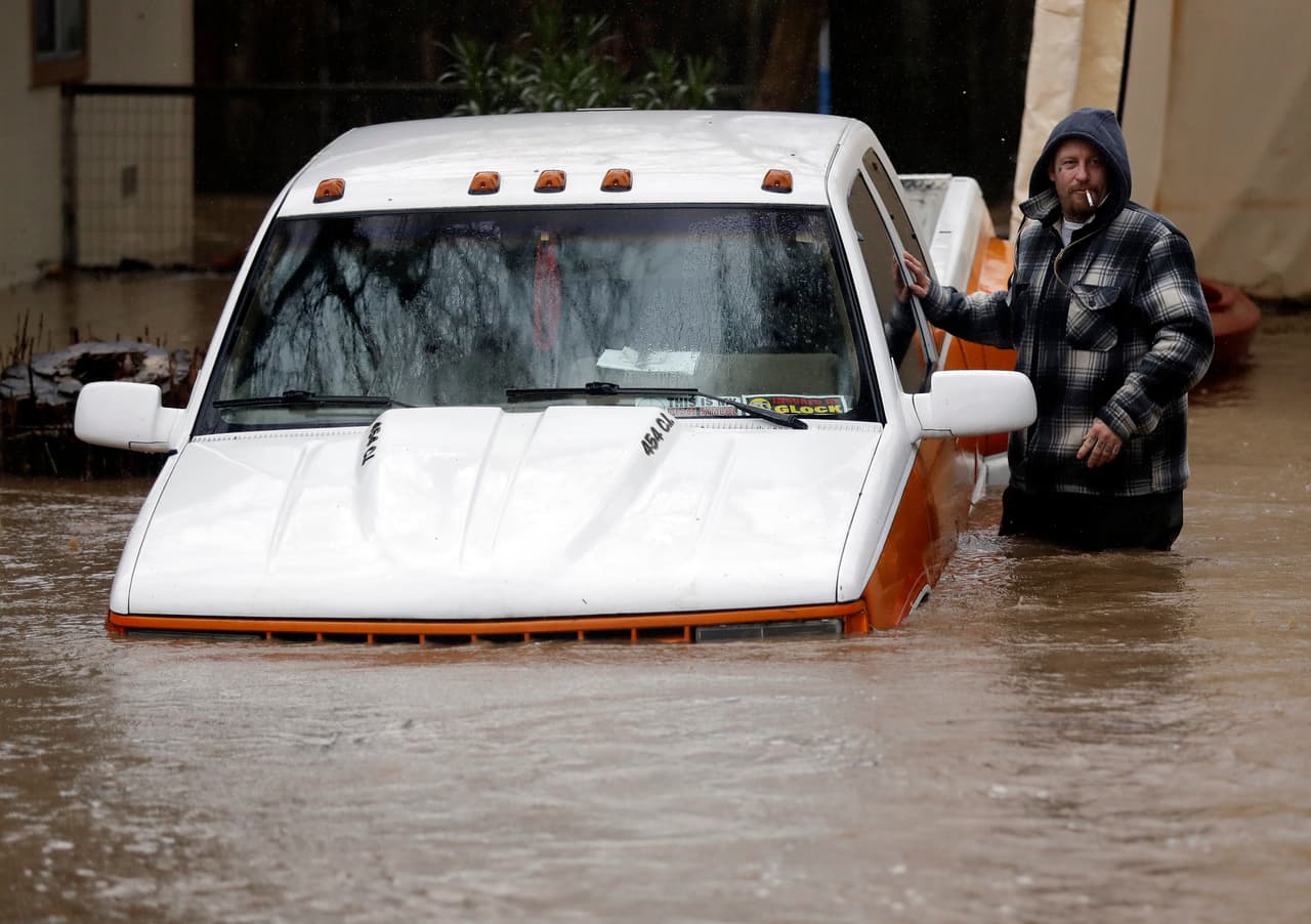 El vehículo de Ross Williams quedó anegado por las aguas del río San Lorenzo a su paso por Felton. El hombre esboza una ligera sonrisa a pesar de la situación.