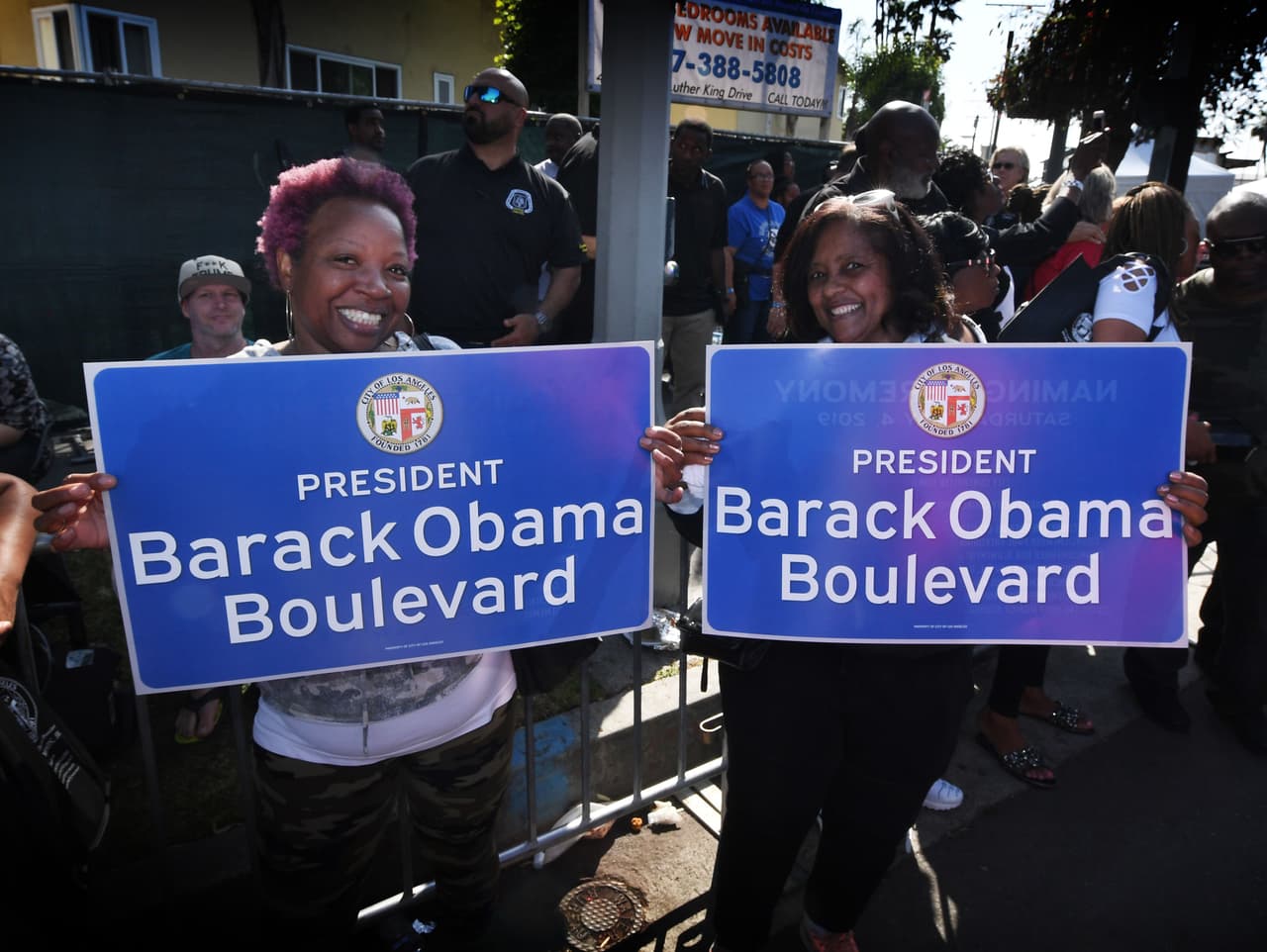 Varios residentes posaron con letreros durante el festival que celebraba el renombramiento de la calle en el sur de Los Ángeles.