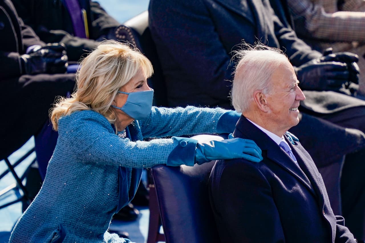 <b>El masaje de la primera dama.</b> Jill Biden dama estaba sentada detrás del presidente y durante la ceremonia acarició sus hombros de forma relajante. Las precauciones por la pandemia hicieron que la distribución de las sillas en el escenario fuese diferente a ceremonias anteriores.