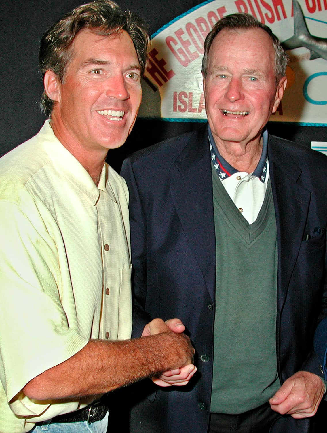 El ex esquiador olímpico Andy Mill recibe las felicitaciones del expresidente George H.W. Bush en noviembre de 2000, luego que Mill ganó una de las categorías del concurso de pesca en Islamorada.