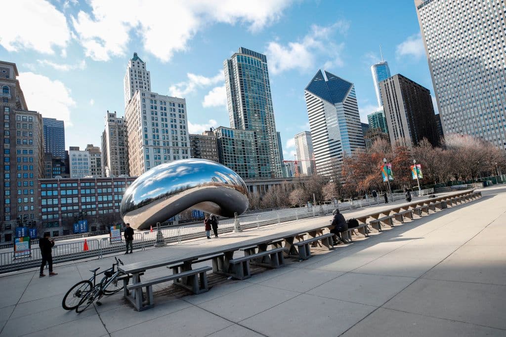 Unas pocas personas frente a la escultura cerrada con vallas de Cloud Gate, conocida como el "Bean", en el Millennium Park de Chicago, Illinois. Casi mil millones de personas fueron 'confinadas' a sus hogares en todo el mundo.
<b> Este domingo 22 de marzo la cantidad de fallecidos en el mundo por el coronavirus ya superó los 13,000. </b>
<br>