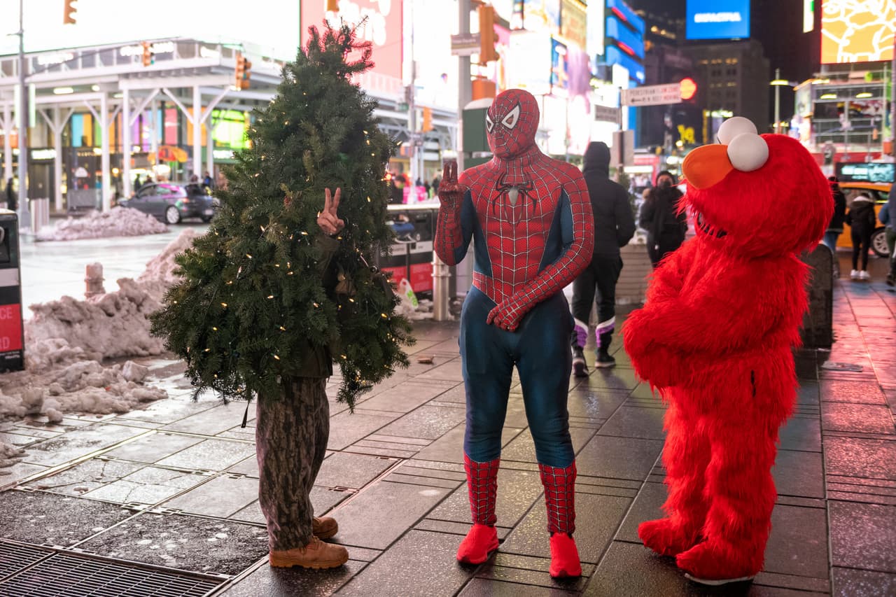 En la foto, el "Señor Árbol de Navidad" habla con otras personas disfrazados de Spiderman y Elmo en Times Square.
