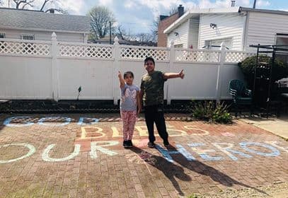 Jayleen de 8 años y su hermano, Adrian Calle de 10 años dibujaron con tiza la vereda para los trabajadores esenciales que pasan por la calle en su barrio de East Elmhurst, Queens.