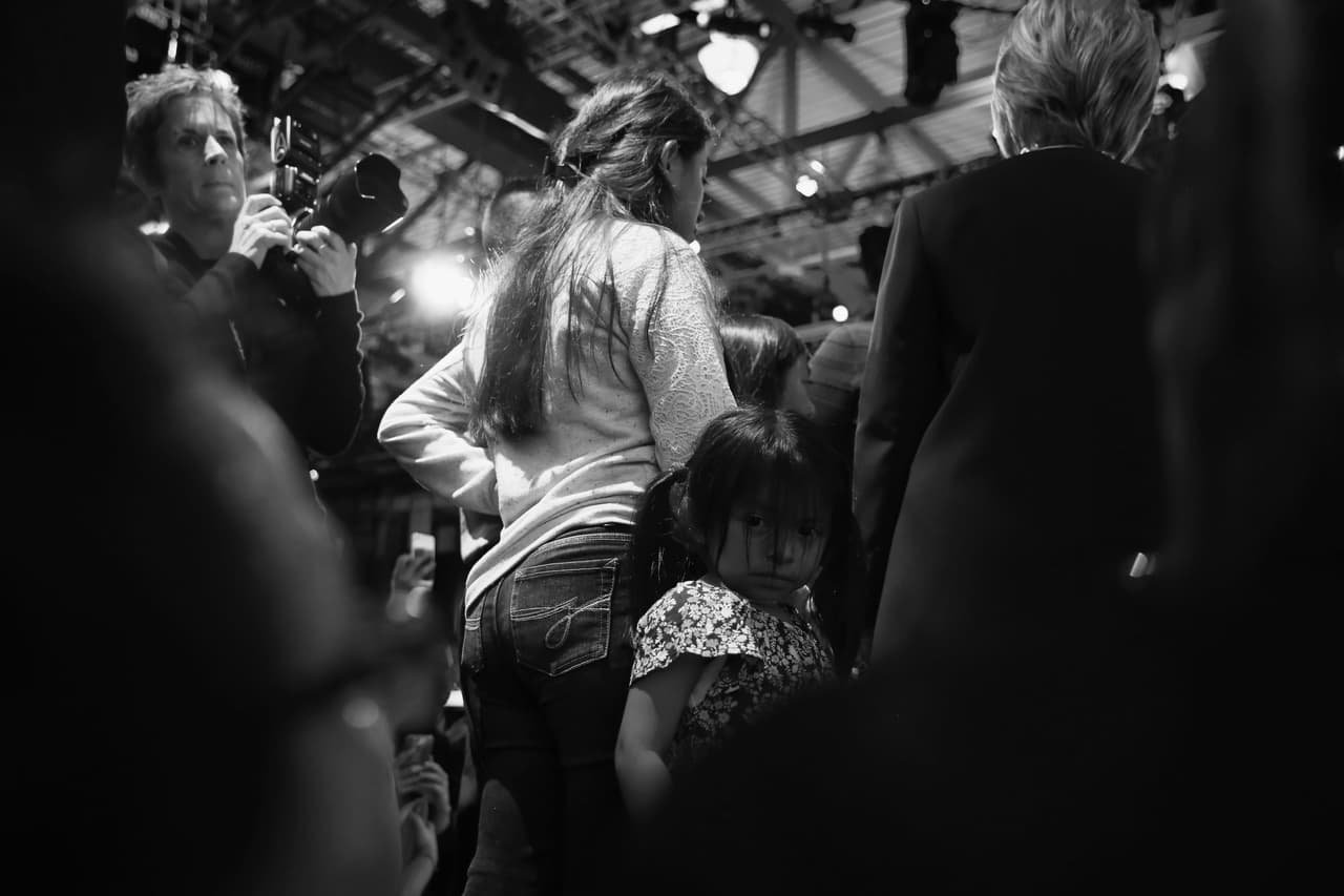 Una de las hijas de Lucía Quiej en mitad de la muchedumbre después del debate mientras su madre habla con Hillary Clinton.