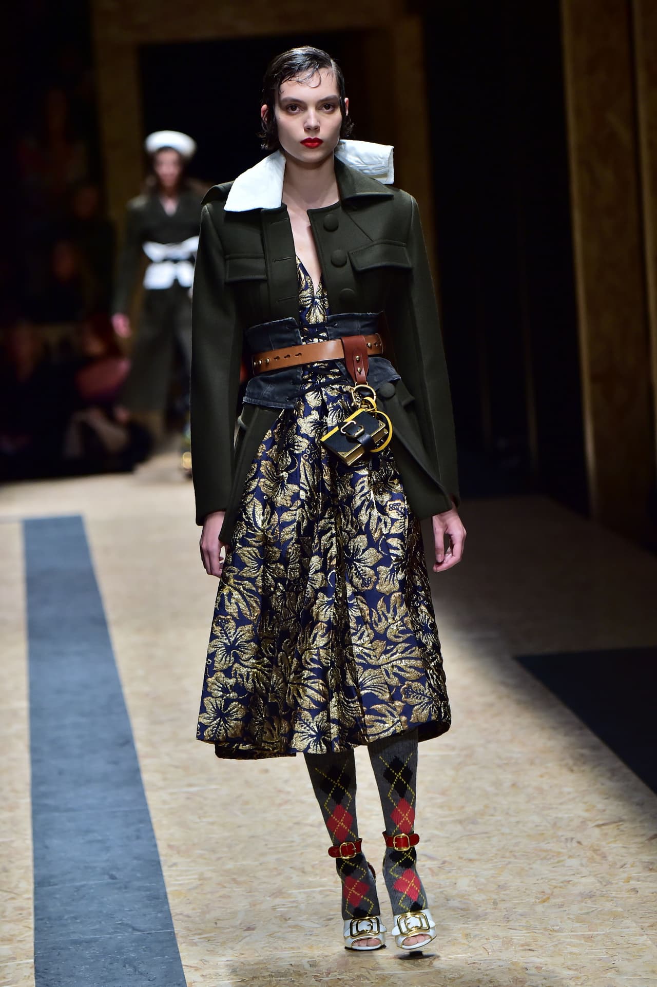 El corsé solo se volvió una prenda de uso exterior gracias al diseñador francés Jean Paul Gaultier, quien en sus colecciones de los 90, lo rescató del olvidó y le dio una nueva vida, ya no como ropa interior, sino como accesorio. Este de Prada sobrepone sigue ese camino de prenda visible y mezcla materiales como el jean y el cuero.