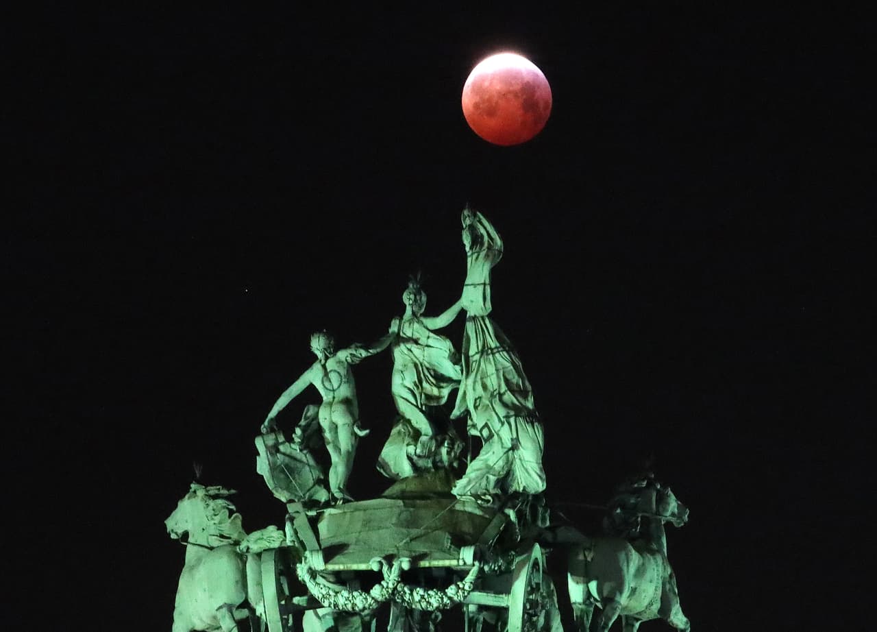 La luna vista detrás de la cuadriga, sobre el arco Cincuentenario de Bruselas, en Bélgica.