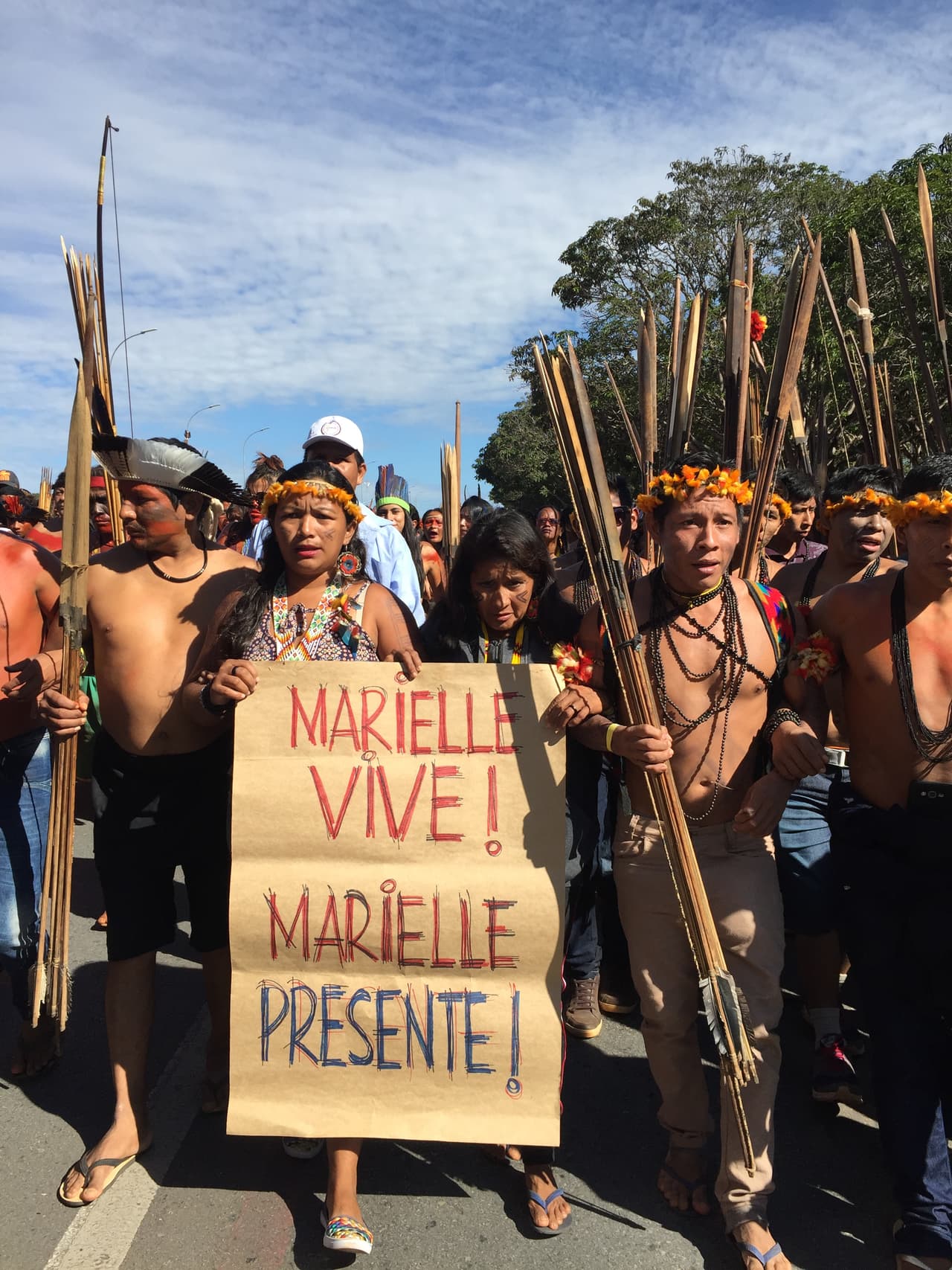 Indigenous protestors hold placard up reading "Marrielli lives," a reference to the recent killing Marielli Franco, a young black LGBT politician from Rio de Janeiro