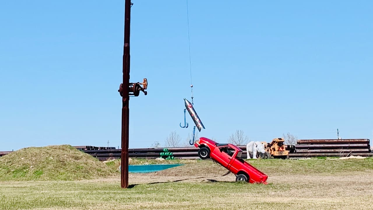 El último trabajo de Lee es la gigantesca caña de pescar que tiene atrapada a una camioneta.