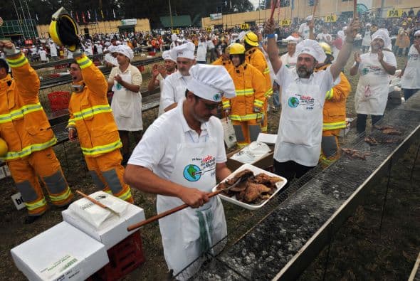 Los cocineros y los bomberos celebran después de obtener el récord Guinness de barbacoa más grande de para asar 26455.471 libras (12, 000 kg) de carne de res en Montevideo el 13 de abril de 2008.