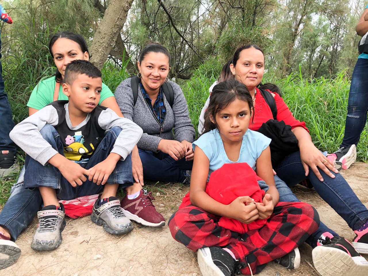 En un viernes reciente de marzo en que Univision Noticias acompañó a la Patrulla Fronteriza, los oficiales procesaron a más de 1,100 personas solo en ese sector denominado 'Valle del Río Grande', según datos de esa agencia federal. Fue un día típico, dicen, que refleja la tendencia de la llegada masiva de unidades familiares. En la foto, la hondureña Roxi Xiomara Hernández (con camisa verde) posa junto a su hijo y a un grupo de madres migrantes que conoció en el camino. "Mi esposo vino aquí hace cuatro meses. Está en Tennessee. Él se vino por la delincuencia. Yo me arriesgué porque el niño no soportaba estar lejos del papá", cuenta.
<br>