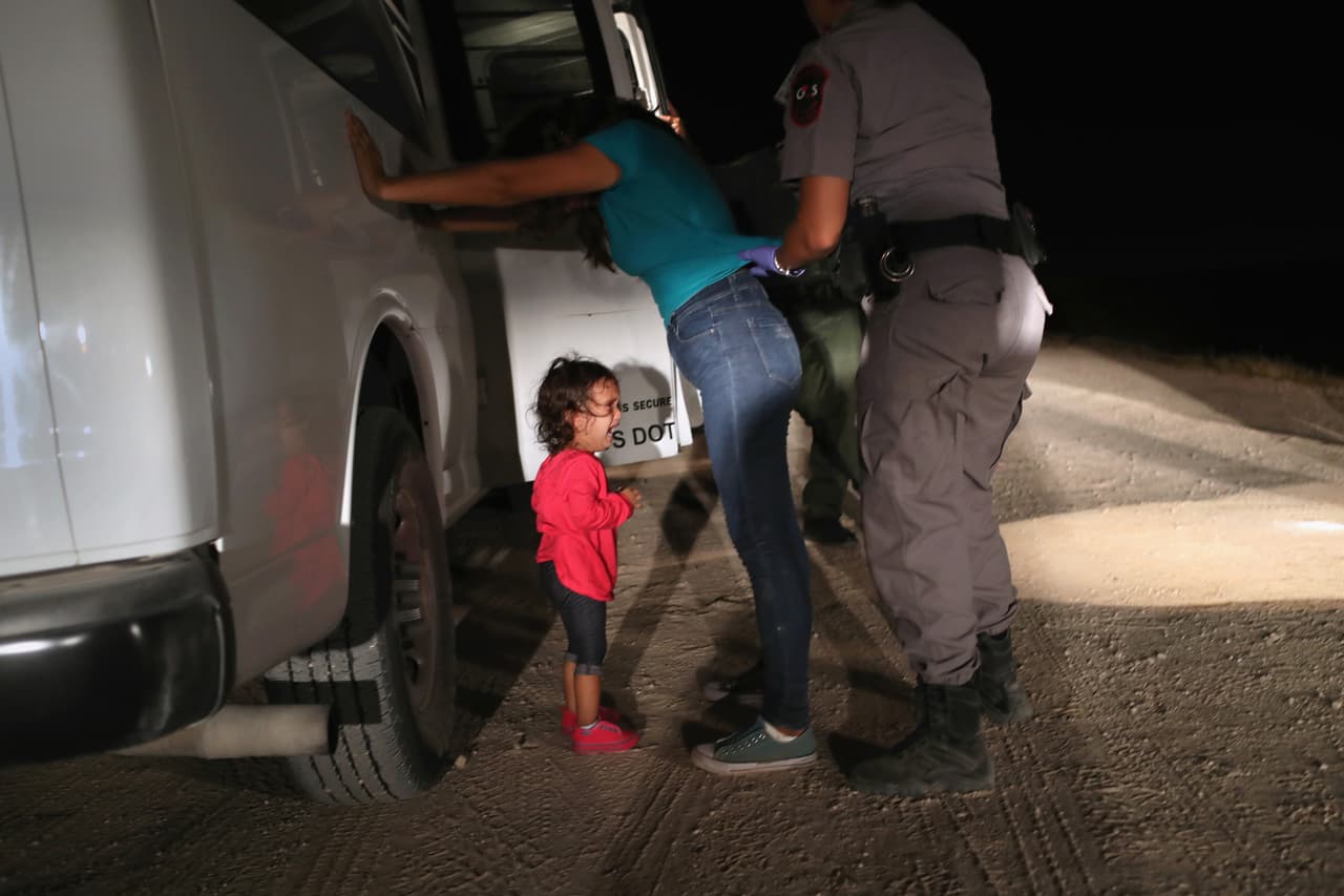Un niño inmigrante llora mientras un agente de la Patrulla Fronteriza la detiene a su madre en el sur de McAllen, Texas, en junio de 2018.
<br>