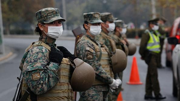 Women soldiers block a main road into Santiago, the capital of Chile, after several communities were placed under quarantine in March.