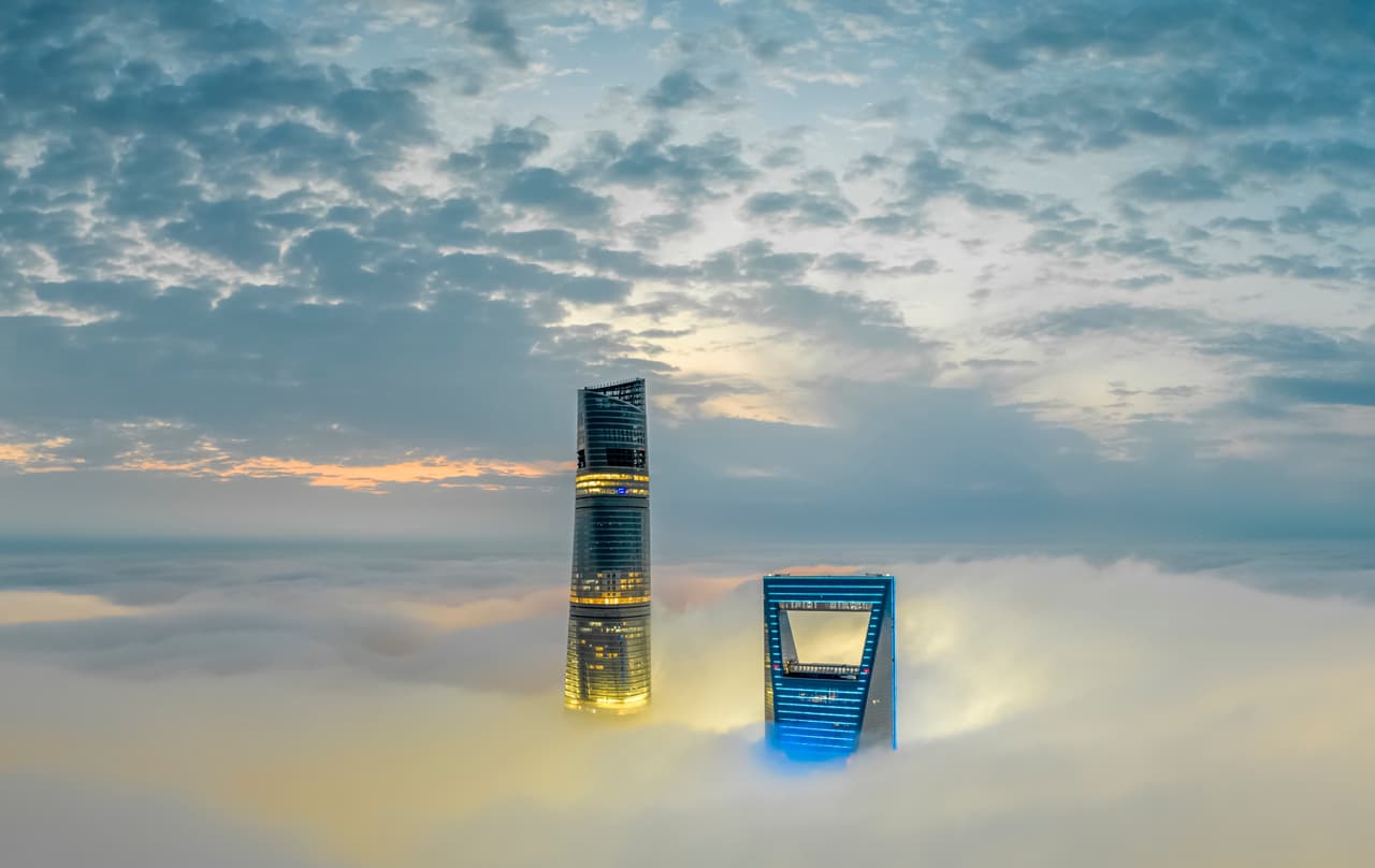 La torre Shangai al atardecer sobre las nubes. El nuevo hotel en los pisos superiores de este edificio compite en excentricidades con el Ritz Carlton de Hong Kong. Este afirma tener la piscina de hotel más alta y el bar de hotel más alto del mundo.
