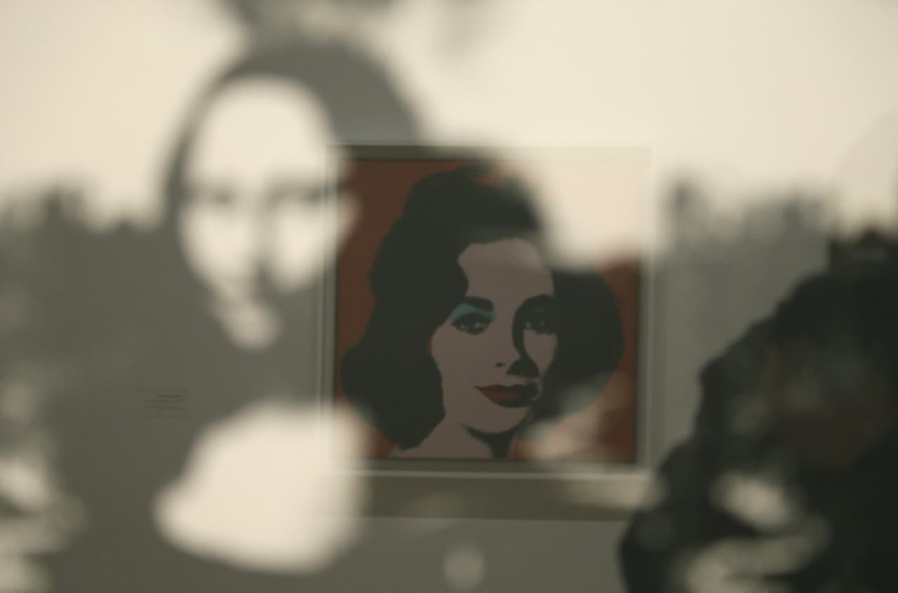 El artista creó cientos de retratos y muchas de sus musas fueron famosas como Elizabeth Taylor, quien en esta imagen aparece reflejada con la Mona Lisa de fondo. Esta colección de personajes formaban parte de "la red social" de Warhol, que incluía no solo a amigos, sino también a familiares, amantes, músicos, actores, atletas y líderes políticos.