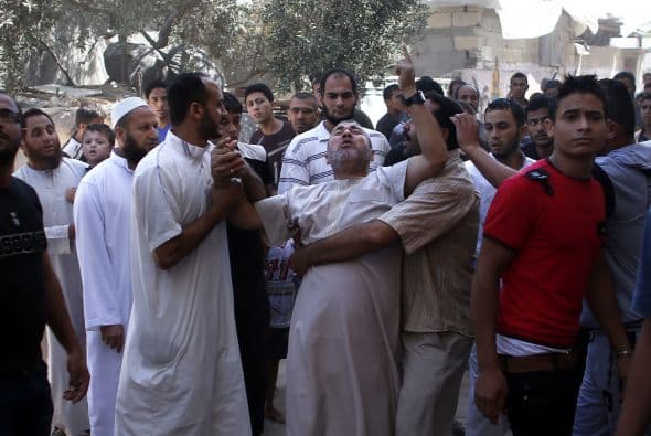 Un palestino reacciona luego de que su casa fue alcanzada por un ataque aéreo israelí.