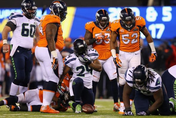 Los Seahawks, con un fútbol "total", el que había trabajado el entrenador del equipo durante toda la temporada regular, el veterano Pete Carroll, derrotaron por paliza de 43-8 a los Broncos, la mejor ofensiva de liga, con el mariscal de campo Peyton Manning a la cabeza. No habían pasado ni 12 segundos desde el comienzo del partido y los Seahawks ya hicieron historia con la anotación más rápida que se había dado jamás en un Super Bowl. Pero lo peor no fue el dejarse anotar dos puntos, sino la imagen de enfrentamiento entre Manning y el centro de origen mexicano Manny Ramírez, que no le dio bien al balón, y aunque el corredor Knowshon Moreno lo recuperó, lo hizo en la zona de protección. La mejor ofensiva de la NFL estaba paralizada, sin saber qué hacer, y ahí fue el comienzo y el final del partido disputado en el MetLife Stadium, de East Rutherford (Nueva Jersey), donde la temperatura fue de 43 grados. Malcom Smith recibió el premio de Jugador Más Valioso (MVP), el octavo defensor que lo consigue en un partido de Super Bowl y el tercer apoyador. Carroll, de 61 años, el tercer entrenador con más edad de la NFL que ganó un Super Bowl, se convirtió en el tercer entrenador que logra los dos títulos de campeón universitario de la NCAA con el equipo de USC y ahora los Seahawks en la NFL.