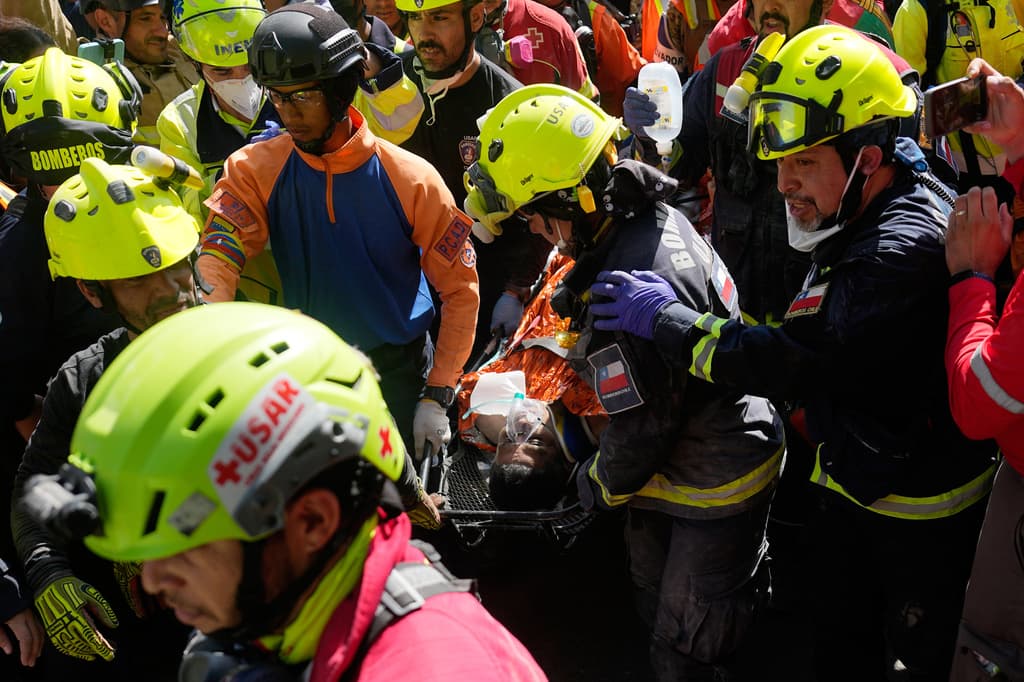 Los rescatistas transportan a Hernán Gil Flores Gil después de que fue sacado de entre los escombros ocho días después de quedar atrapado por los dos terremotos que azotaron Catia La Mar, Venezuela, el jueves 2 de julio de 2026. (AP Foto/Fernando Vergara)