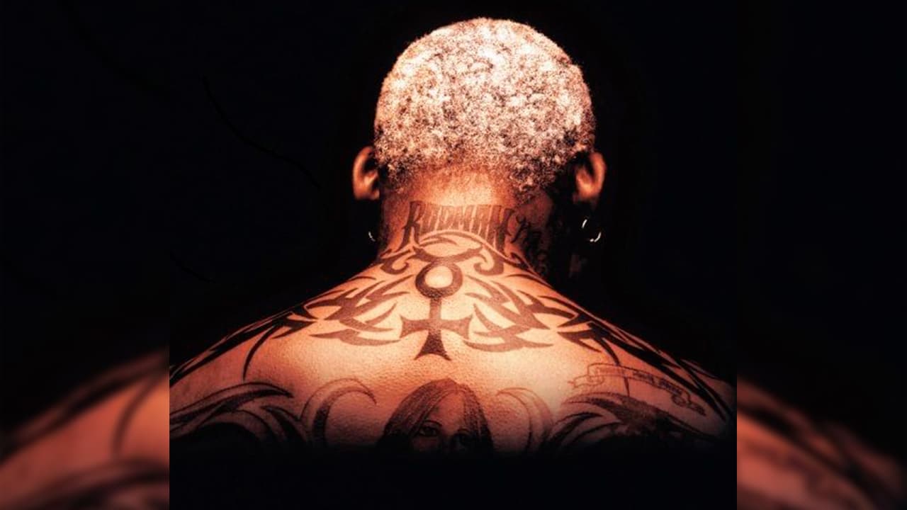 Su apellido en la nuca denota su lado narcisista. También podemos ver la cabeza de otra figura femenina.