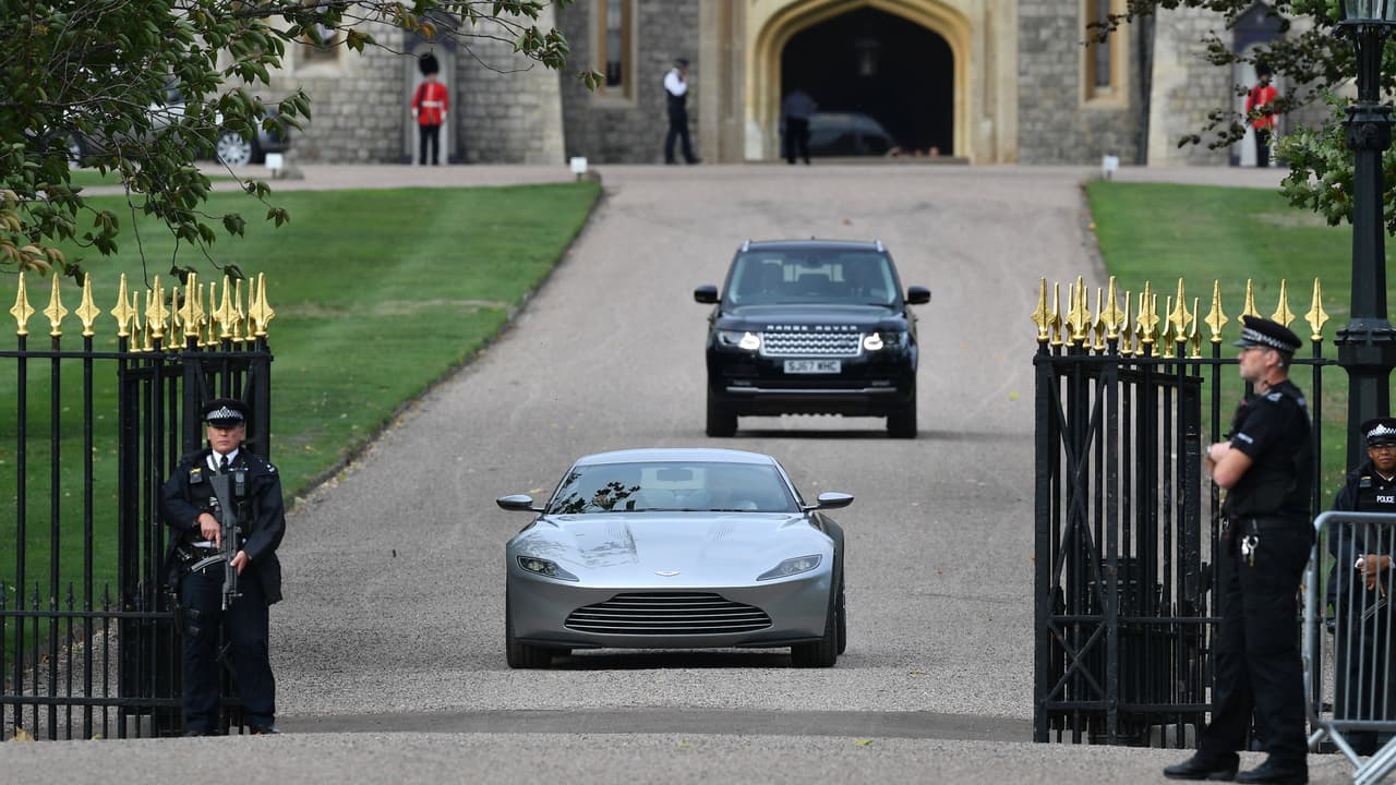En esta imagen digna de una película de James Bond, los novios atraviesan la verja del palacio de Windsor a bordo del Aston Martin DB10.