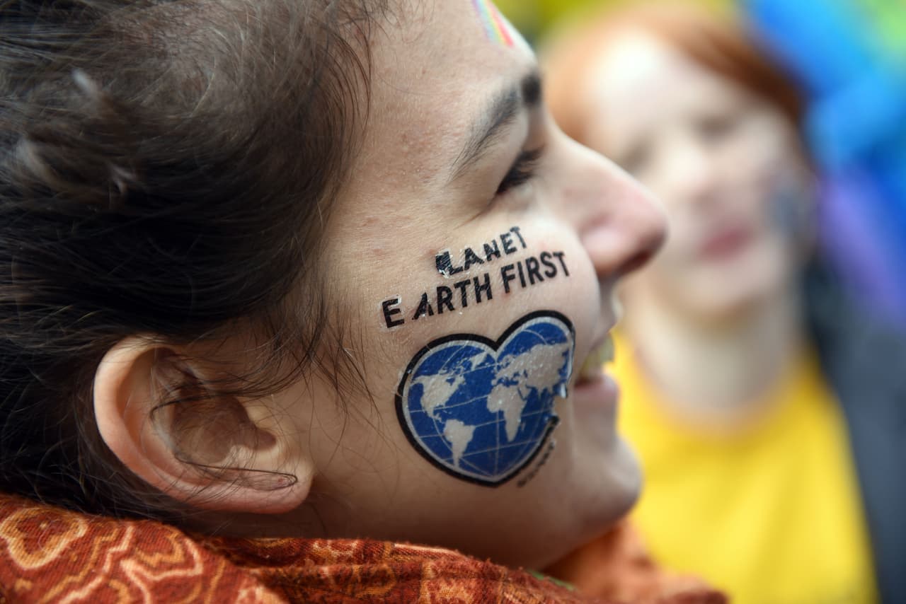 "Primero va el planeta Tierra", dice el rostro de esta joven sonriente en Bonn.