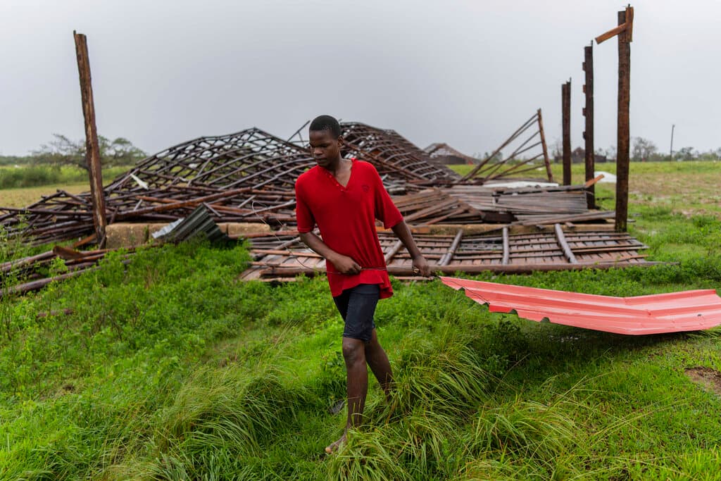 Un hombre recupera un pedazo de techo volado de una estructura en una plantación de tabaco, después de que el huracán Ian azotara Pinar del Río, Cuba.