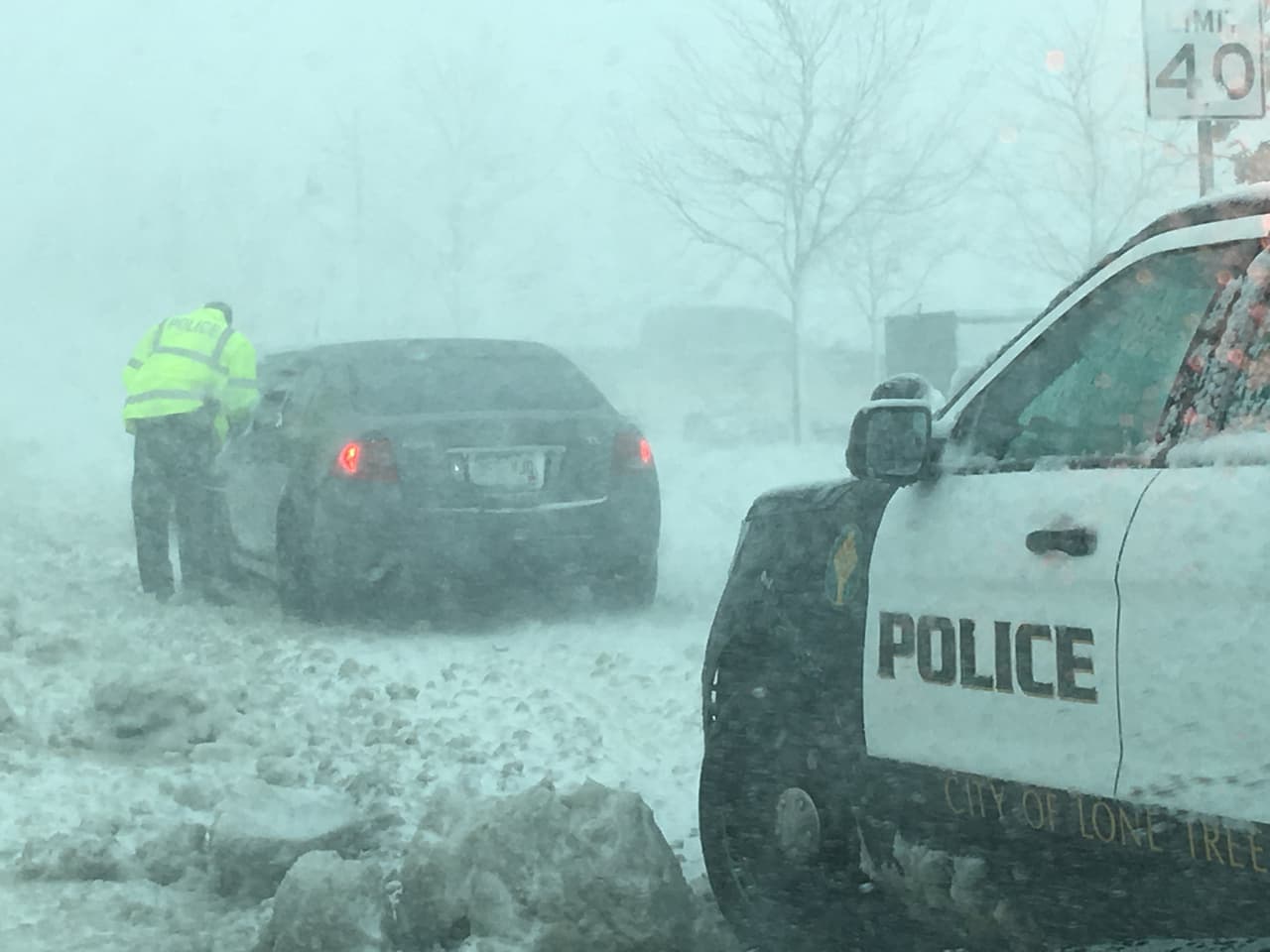 Un agente de la policía conversa con un conductor atascado en una vía de Lone Tree, Colorado.