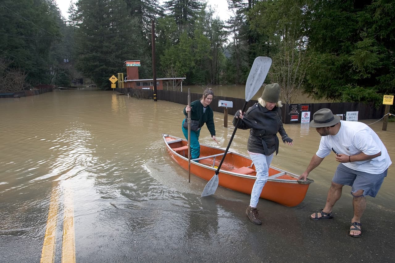 GUERNEVILLE, CA - JANUARY 2: People take water ferries via canoes and small boats back and forth to their homes off Drake road from a flood on January 2, 2006 in Guerneville, California. Northern California has been inundated by heavy rain over the past week, causing mudslides and rivers to spill over their banks. (Photo by David Paul Morris/Getty Images)