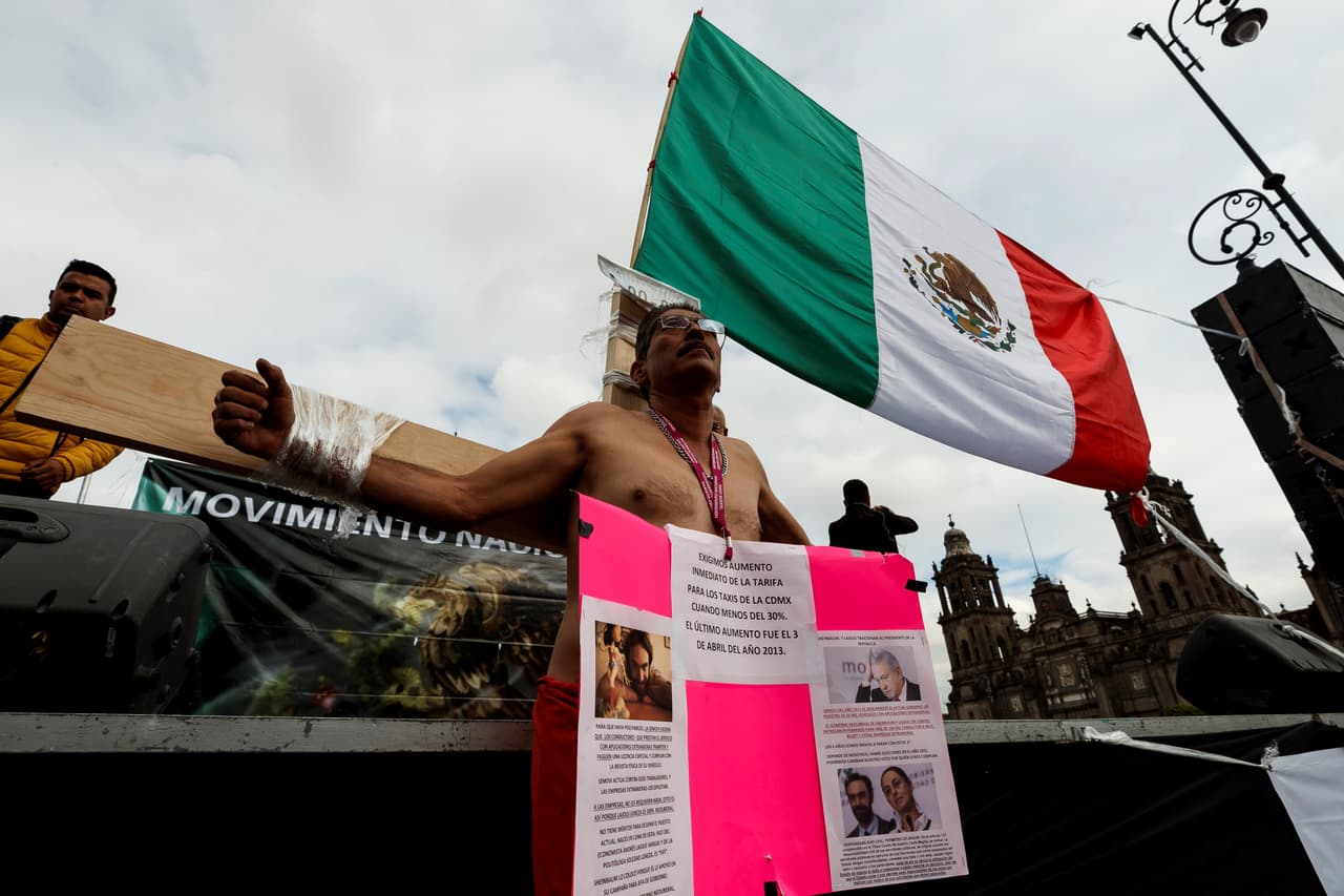 Un taxista simula estar crucificado en el Zócalo de Ciudad de México, durante la protesta. EFE/ José Méndez