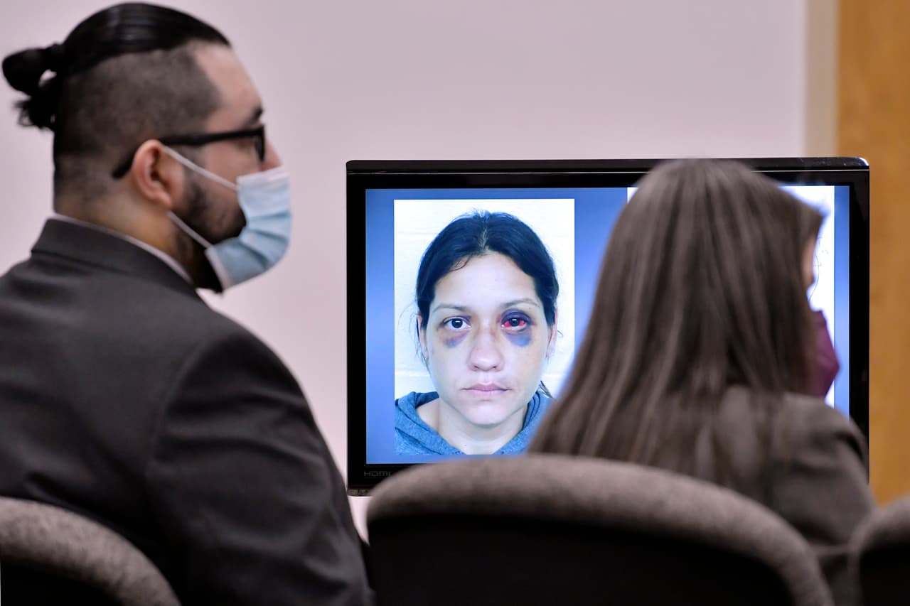 Una imagen de Britany Barron en una pantalla del juicio contra Armando Barron, quien aparece a la izquierda de la imagen.