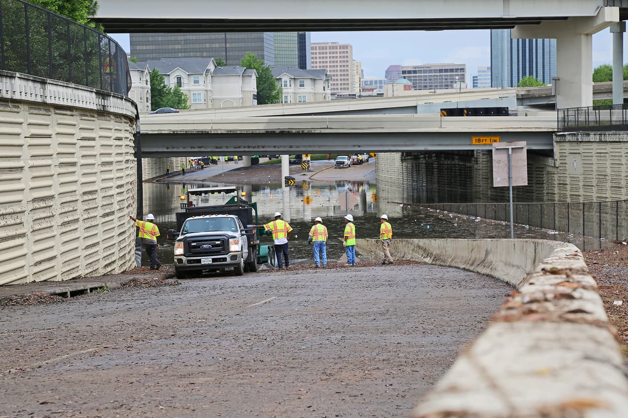 Equipos de trabajadores especializados en drenaje de aguas estancados esperan con paciencia a que las máquinas de bombeo terminen su trabajo.