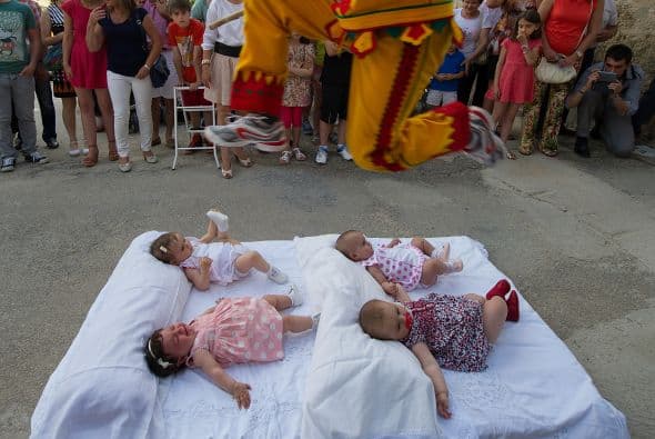 Los bebés permanecen tumbados en colchonetas en la calle y engalanados con sus mejores ropas.