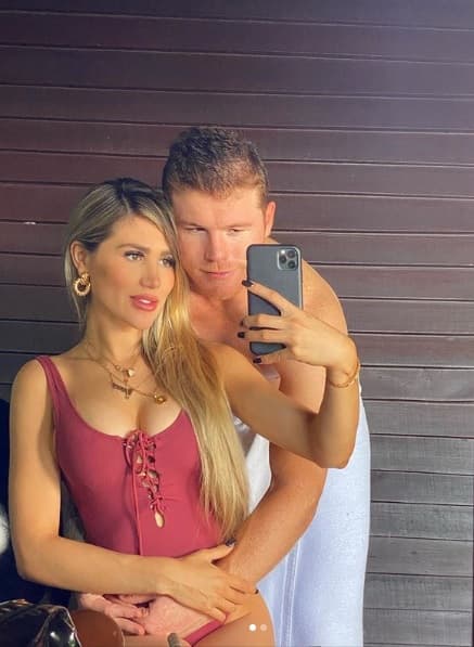 En otra fotografía, el boxeador
<b>abraza a la modelo,</b> mientras ella toma su teléfono para capturar el momento.