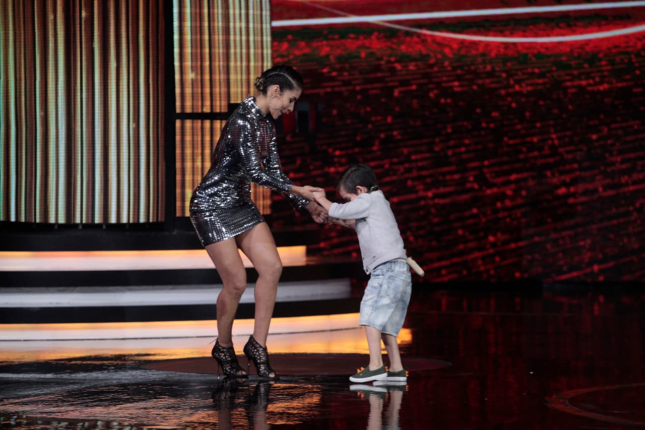 María volvió a tomarlo de ambas manos y siguieron bailando. Mientras, él observaba atento los movimientos de los pies de la cantante, para tratar de imitarlo.
