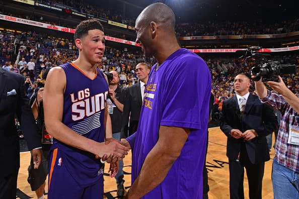 Devin Booker # 1 de los Phoenix Suns se da la mano con Kobe Bryant # 24 de Los Angeles Lakers después de un juego en el Talking Stick Resort Arena el 23 de marzo de 2016 en Phoenix Arizona.