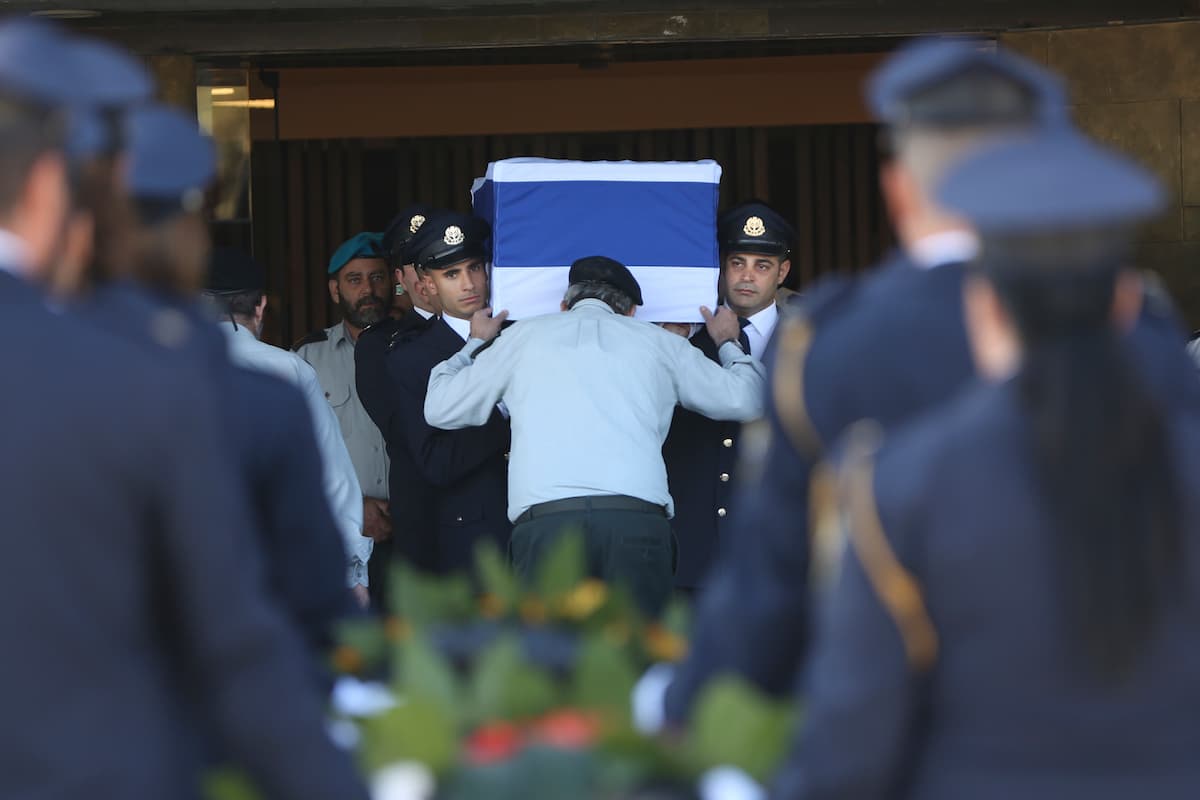 Miembros de la guardia Knesset trasladan el féretro hasta el sitio donde será colocado para la ceremonia del viernes.