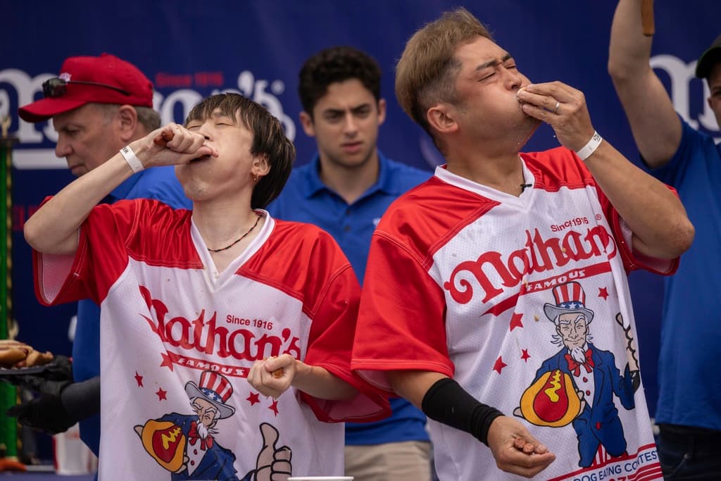 El comedor competitivo japonés Max Suzuki, a la derecha, y Ren Zoza, a la izquierda, comen perros calientes durante el concurso Nathan's.