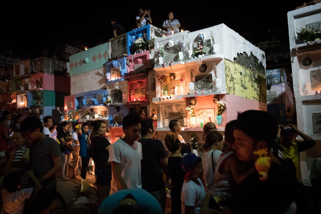 <b>Filipinas.</b> Ofrendas y cantos en un cementerio de Manila.