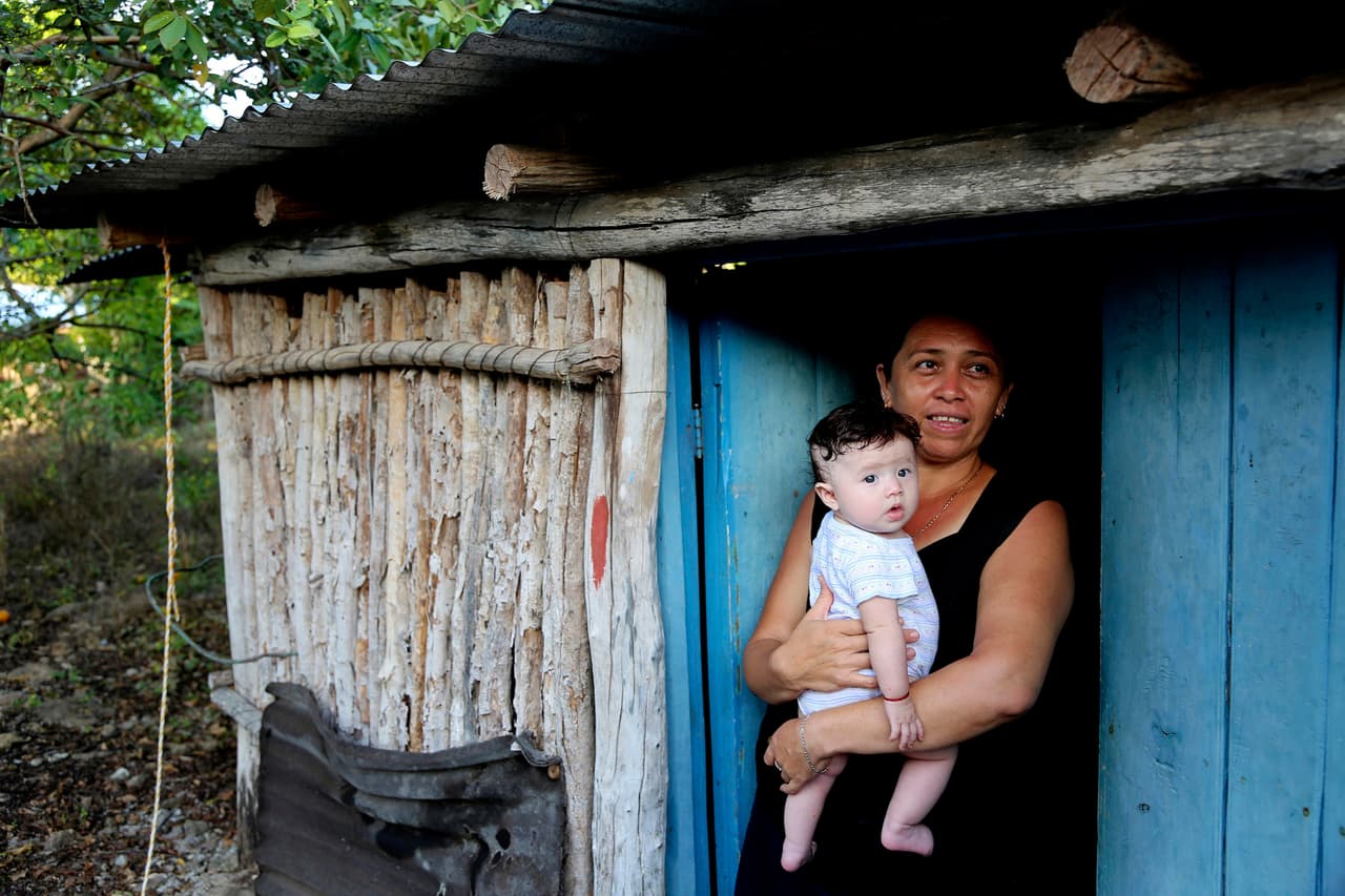 Sonia, de 41 años, con su nieta. Su marido se fue a Estados Unidos hace 17 años y aún no ha regresado. “La gente cambia cuando cruza la frontera, pero a menudo para peor”, dice quien vive en Tunkás. Joey Rosa/Ubelong