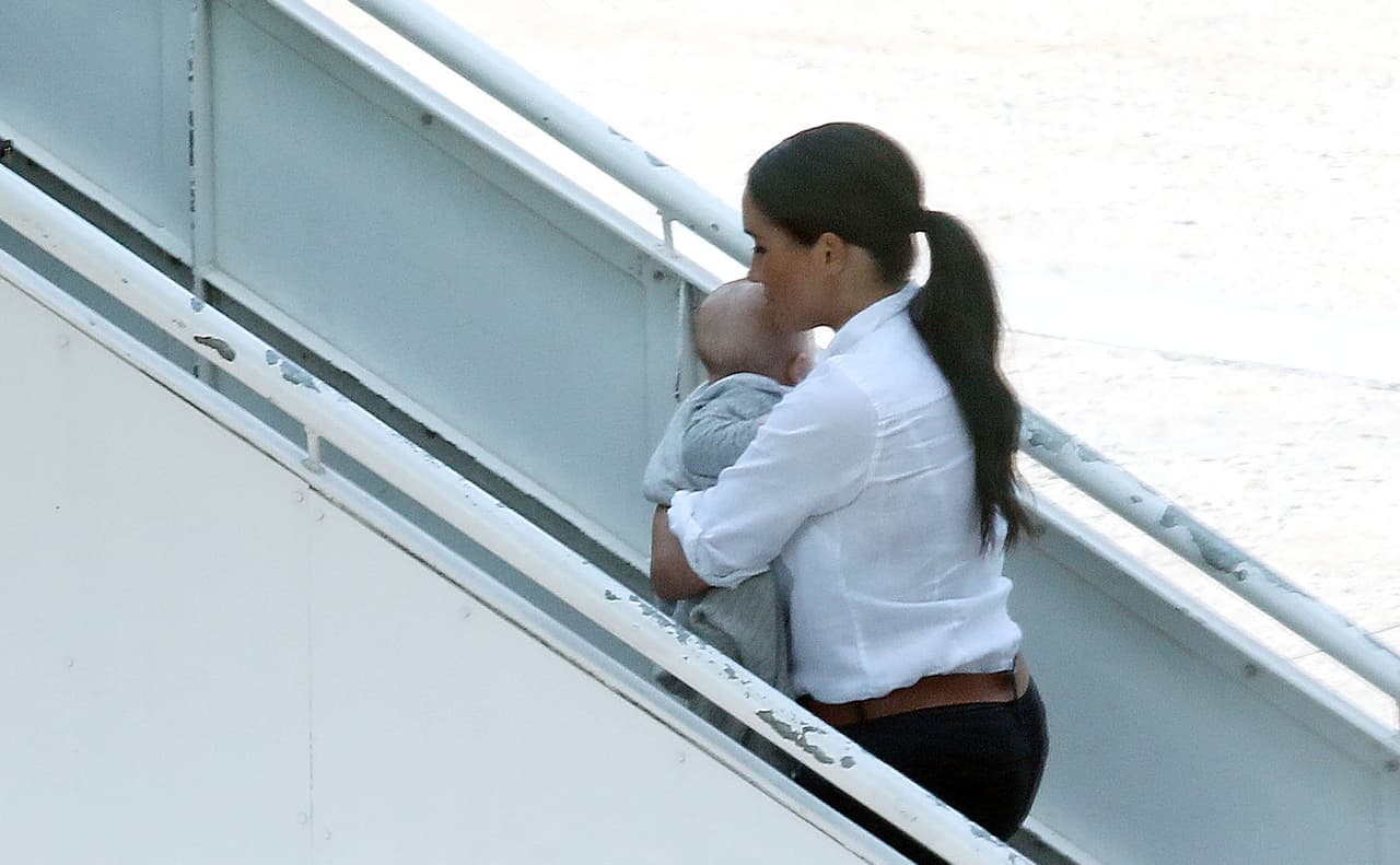 Vestida con un pantalón negro, camisa blanca y zapatos de tacón, Markle tomó un vuelo de British Airways rumbo a Johannesburgo, en donde volvió a reunirse con el príncipe Harry.