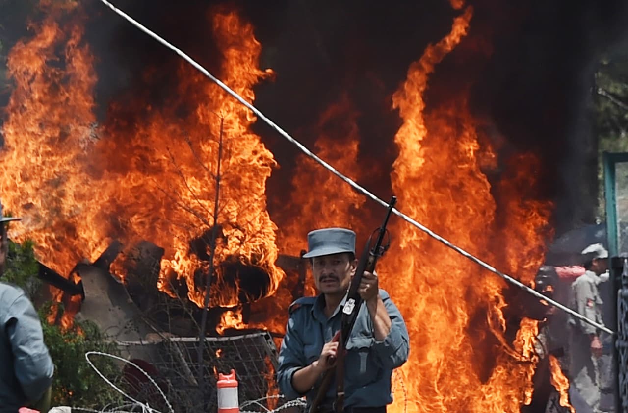 Un afgano monta guardia frente al incendio ocasionado por una gran explosión cerca del aeropuerto internacional de Kabul, agosto de 2015.