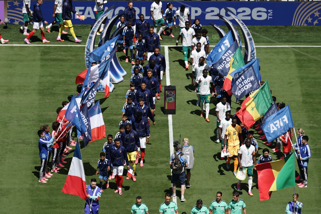 Jugadores franceses (a la izquierda) y senegaleses saltan al campo antes del partido de fútbol del Grupo I de la Copa del Mundo entre Francia y Senegal en East Rutherford.