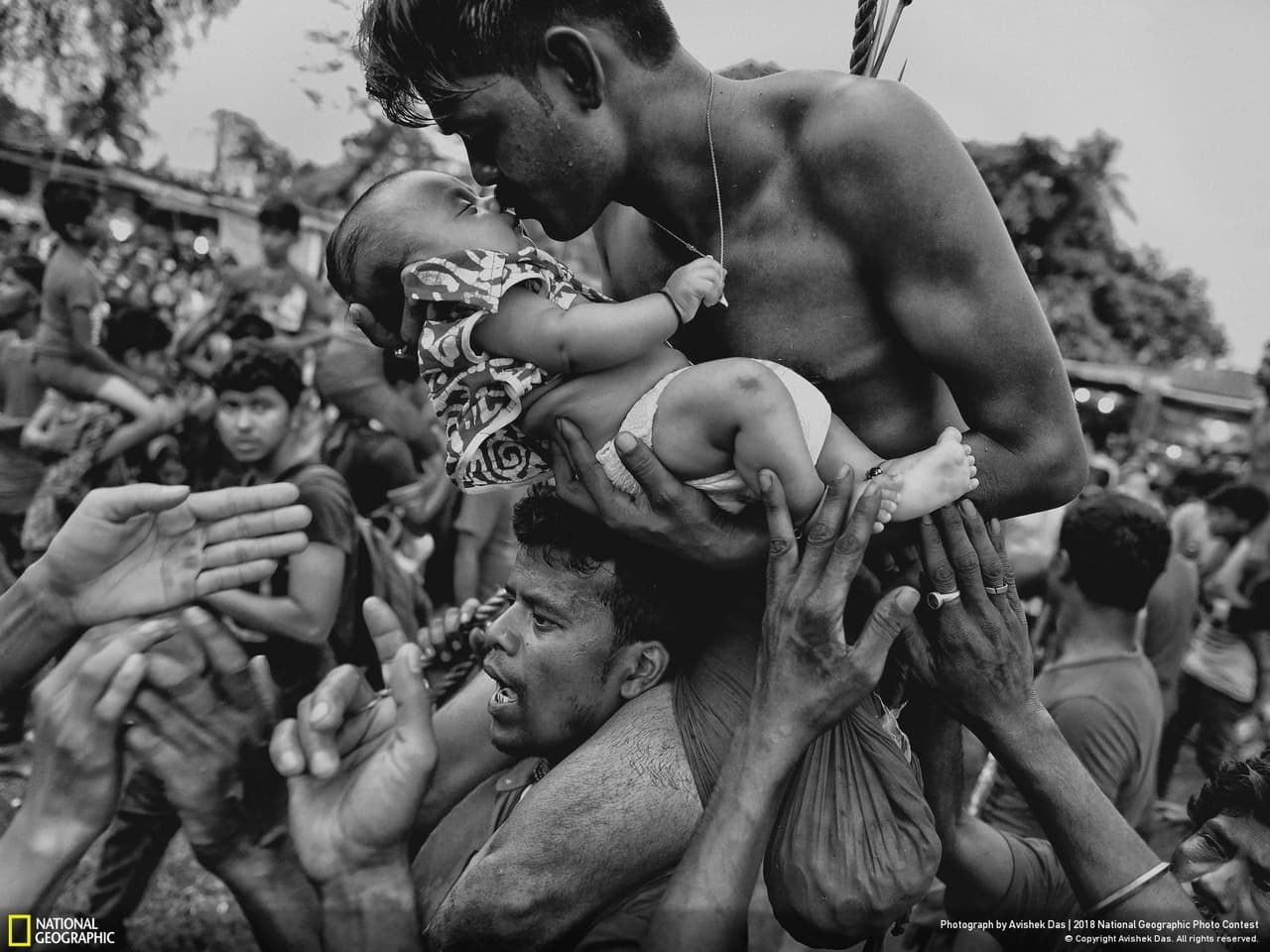 <b>Amor de mi vida</b>. “Un devoto hindú besa a su bebé recién nacido durante el festival Charak Puja en Bengala Occidental, India. La práctica tradicional exige que el devoto sea perforado con un gancho y, a veces, blandido desde una cuerda. Este doloroso sacrificio se realiza para salvar a los hijos de la ansiedad. Mientras cubría el festival, pude ver la práctica religiosa desde la perspectiva de los devotos hindúes. Traté de capturar el momento de amor entre un padre y su hijo, y mostrar la preocupación de un padre por su pequeño", contó el autor sobre la imagen, tercer premio en la categoría ‘Gente’.
