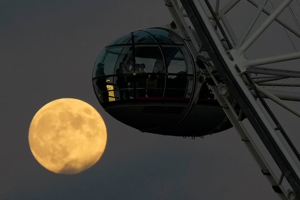 Esta gráfica capta el momento en que 'Luna fría' aparece detrás de una cápsula de la noria London Eye en Londres.